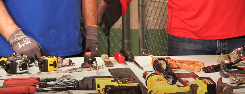 Two contractors setting various cutting and forming tools on a wooden table